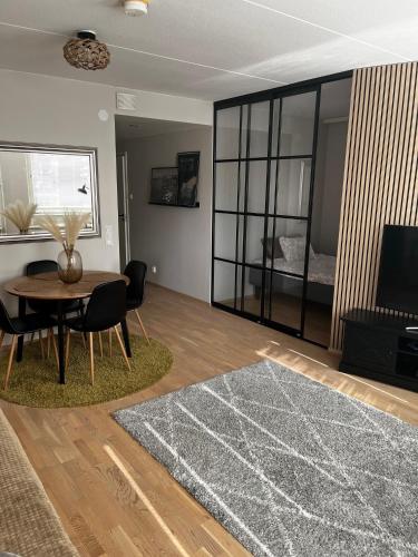 a living room with a table and chairs and a television at Great two bedrooms apartment with a sea view from the balcony close Helsinki center in Helsinki