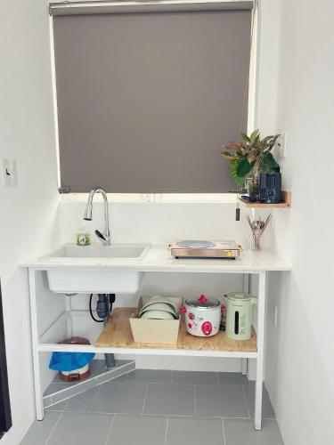 a kitchen counter with a sink and a shelf at Yen Minh Resthouse in Ho Chi Minh City