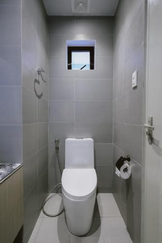 a white bathroom with a toilet and a window at ACHITEL Tarlac in Tarlac