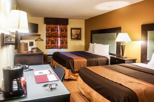 a hotel room with two beds and a desk at Cocoa Country Inn Hershey in Hershey