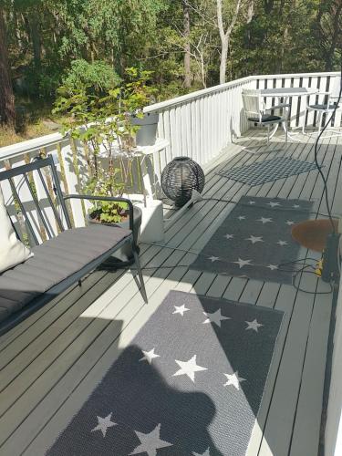 a deck with a rug with stars and a bench at Det Vita Huset in Stockholm