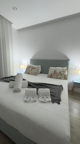 a large white bed with two towels on it at Vila D`arte Vila de Rei in Vila de Rei