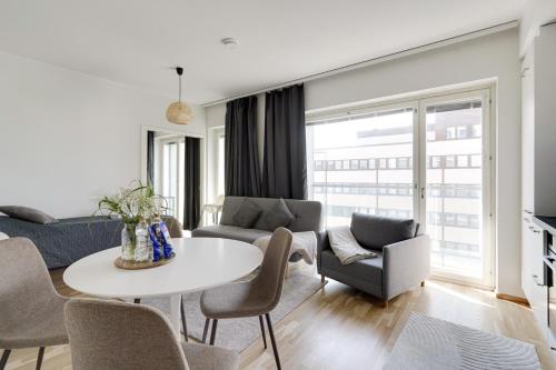 a living room with a table and chairs at Mall of Tripla apartments by Come in! in Helsinki