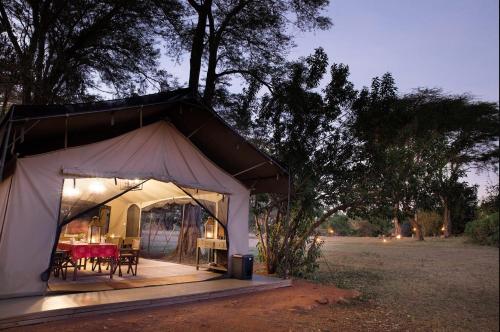 a tent with tables and chairs in a field at Basecamp Adventure in Masai Mara