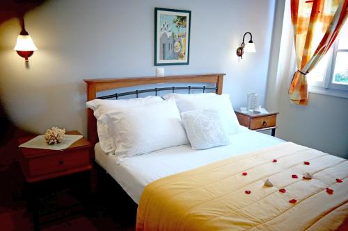 a bedroom with a bed with white sheets and pillows at Maroussa Studios in Agia Anna Naxos
