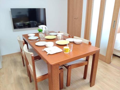 a wooden dining room table with chairs and plates on it at 大和の宿 Kitabukuro202 in Nara