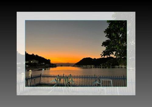 a picture of a sunset over a body of water at Pousada Prainha do Horizonte in São Vicente