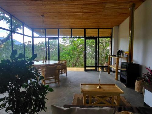 Una sala de estar con una mesa y una gran ventana. en Ntchisi Forest Lodge, 