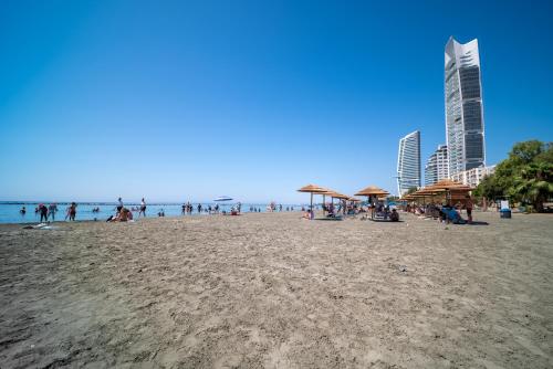 a group of people on a beach near the ocean at Casa Sol - Bright 3BR Steps from the Beach & Shops in Limassol