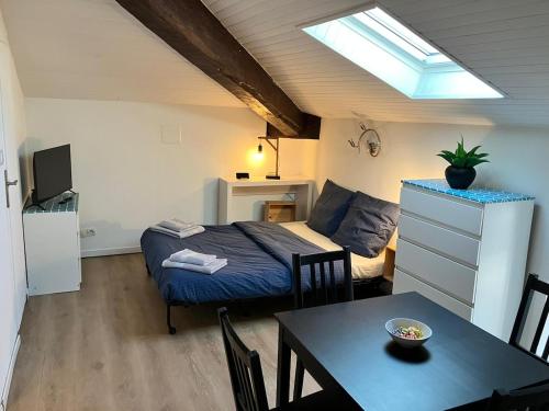 a bedroom with a bed and a table and a room with a dining room at Charmant Studio - Centre Dax in Dax