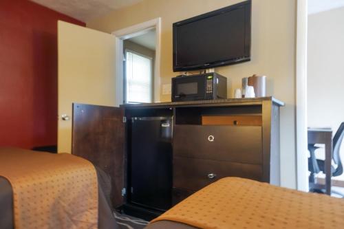 a hotel room with a television and a dresser at Cocoa Country Inn Hershey in Hershey