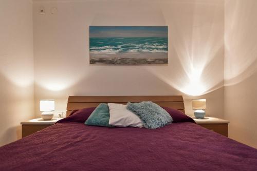 a bedroom with a purple bed with two lamps at Vila Biserka in Stara Baška
