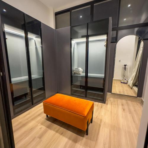 an orange ottoman in a room with mirrors at Luxury Smart Apartment B12 in Riyadh