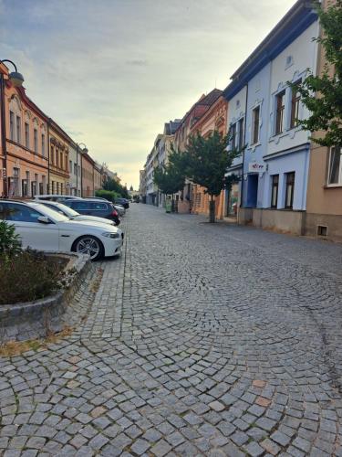 a cobblestone street with cars parked on it at Moderní apartmán s balkonem v srdci Pardubic in Pardubice