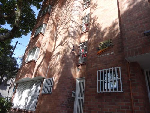a red brick building with white doors and windows at Amoblados Medellín Laureles in Medellín