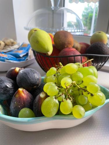 a bowl of fruit on a table with a basket of fruit at Dimora Don Ciccillo B&B in Bagnara Calabra