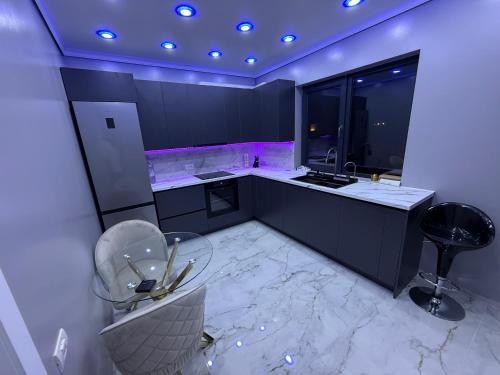 a kitchen with black cabinets and a marble floor at Vila luxury chiajna in Chiajna