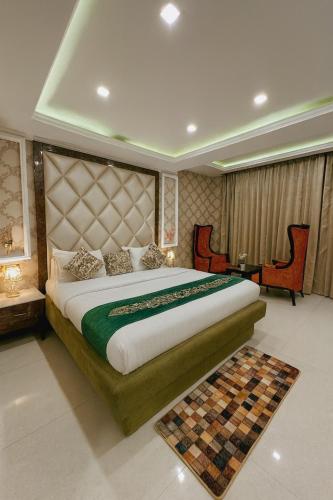 a bedroom with a large bed and a table and chairs at The Four Season Dharamshala # Centrally Heated & Air Cooled # Scenic Mountain View # Big Parking # Near Market # Top Rated # Most Awarded # Premium Rooms # Bar # Terrace # Lift # Property Of The Year##BY ROYAL GROUP# in Dharamshala