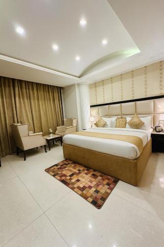 a bedroom with a large bed and a table and chairs at The Four Season Dharamshala # Centrally Heated & Air Cooled # Scenic Mountain View # Big Parking # Near Market # Top Rated # Most Awarded # Premium Rooms # Bar # Terrace # Lift # Property Of The Year##BY ROYAL GROUP# in Dharamshala
