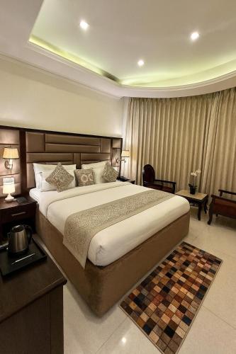 a bedroom with a large bed in a hotel room at The Four Season Dharamshala # Centrally Heated & Air Cooled # Scenic Mountain View # Big Parking # Near Market # Top Rated # Most Awarded # Premium Rooms # Bar # Terrace # Lift # Property Of The Year##BY ROYAL GROUP# in Dharamshala