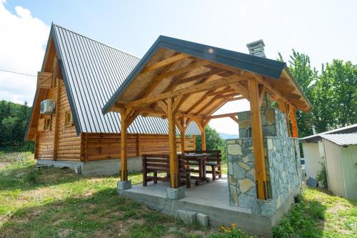 a wooden cabin with a table and a gazebo at Etno House Markovic in Kolašin