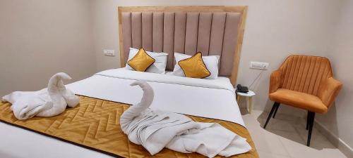 two swans made out of towels on a bed at Hotel MGM Grand in Srikalahasti