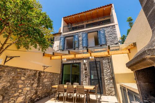 a building with a table and chairs in front of it at Port and Stone Villa in Funchal