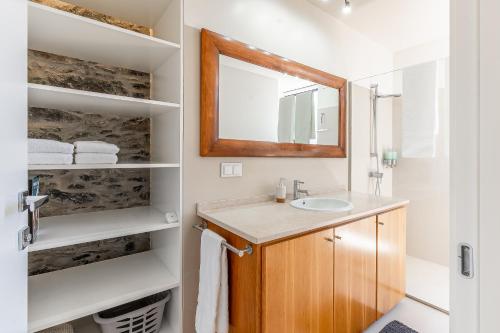 a bathroom with a sink and a mirror at Port and Stone Villa in Funchal