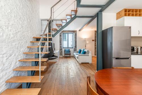 a staircase in a living room with a couch and a table at Port and Stone Villa in Funchal