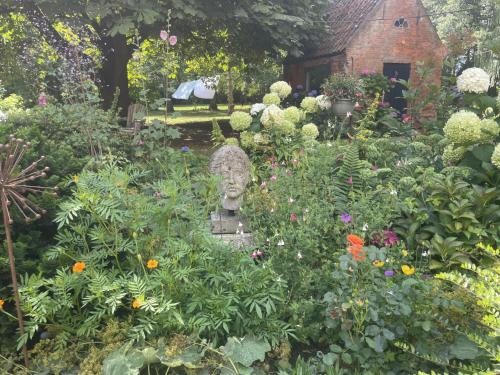 a garden with a statue in the middle at d'oude hoeve in Rijsbergen