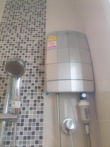 a machine in a bathroom with a tiled shower at Homestay At Foret Iconature Salaya in Sathani Wat Suwan