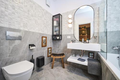 a bathroom with a sink and a toilet and a mirror at Central oLiv Apartment with free parking in Timişoara