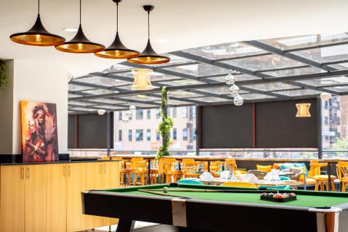 a ping pong table in a restaurant with a pool table at Kingfisher Nest Hotel Suites- Westlands, Near Sarit Center in Nairobi