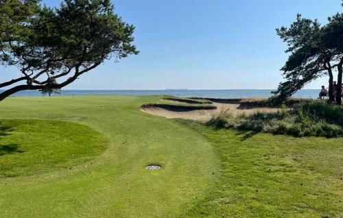 a golf course with the ocean in the background at 3 Bedroom Awesome Home In Gotlands Tofta in Tofta