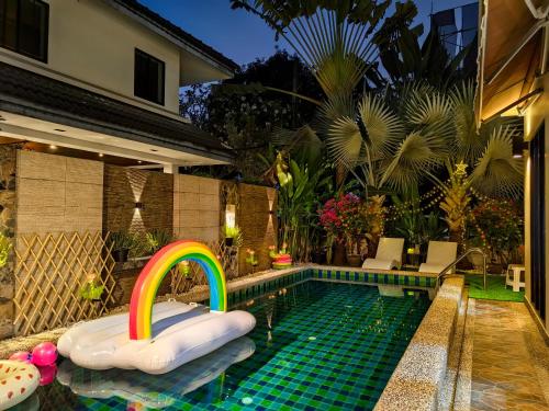a swimming pool with a rainbow in the middle at Thonglor 25 Noble House in Bangkok