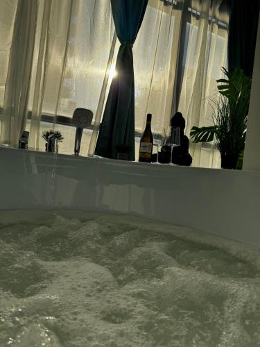 a tub filled with water in a room with a window at InspireNest Iulius Mall in Cluj-Napoca