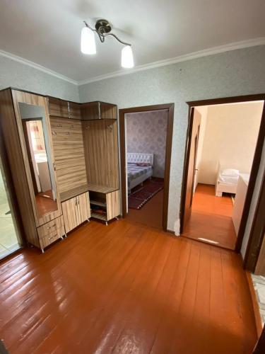 an empty room with wooden floors and a bedroom at Aiza Apartments in Naryn