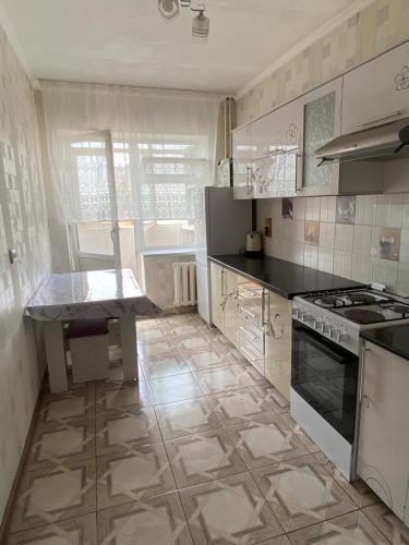 a kitchen with a stove and a counter top at Aiza Apartments in Naryn