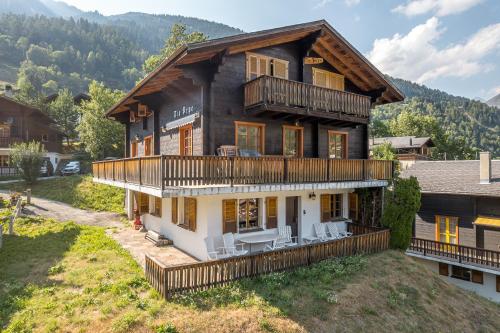 a large log house with a balcony and chairs at Tio Pepe OG in Fiesch