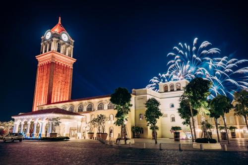 a clock tower and a building with a firework at The Hill Apartment - Phú Quốc - Firework & Ocean View in Phu Quoc