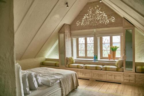 a bedroom with a bed and a large window at Posiadłość Wiejska i Ogrody Acqua di Rosa in Zameczek