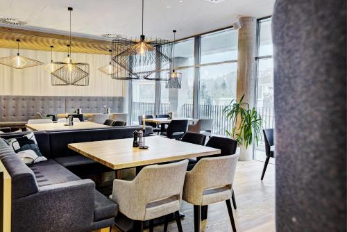 a restaurant with tables and chairs and windows at Königswieser Hof in Königswiesen