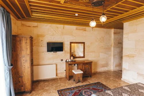 a room with a desk and a tv on a wall at Nest Cappadocia Hotel in Uchisar