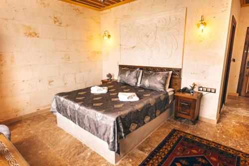 a bedroom with a large bed and a night stand at Nest Cappadocia Hotel in Uchisar