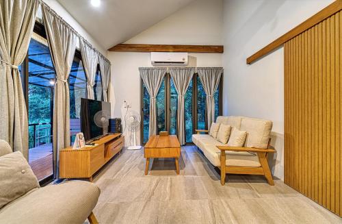 a living room with a couch and a tv at Nan Homey Space น่านโฮมมี่สเปซ in Nan