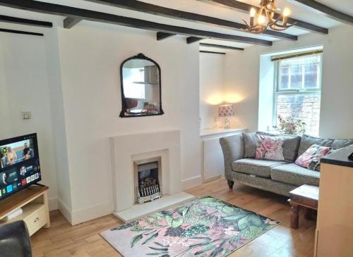 a living room with a couch and a fireplace at Chantry Place Morpeth House in Morpeth
