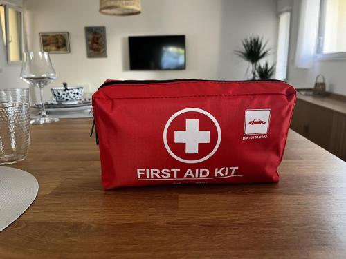 a red first aid kit sitting on top of a table at Maison 80 m2 à 5mn de Nantes in Sautron