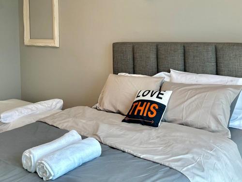 a bed with two pillows and a sign that says love this at Golden Sand Couple Suites near CIQ 1B1B in Johor Bahru
