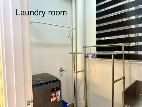 a laundry room with a laundry machine in the corner at Golden Sand Couple Suites near CIQ 1B1B in Johor Bahru