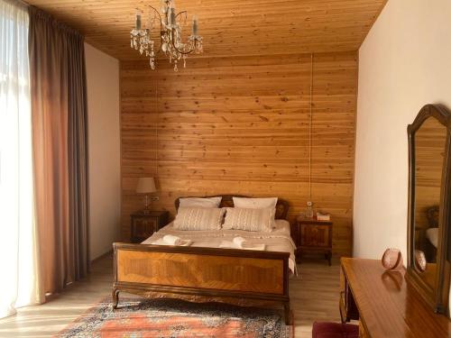 Un dormitorio con una cama con una pared de madera. en Guest House Chalistavi, en Chalist'avi